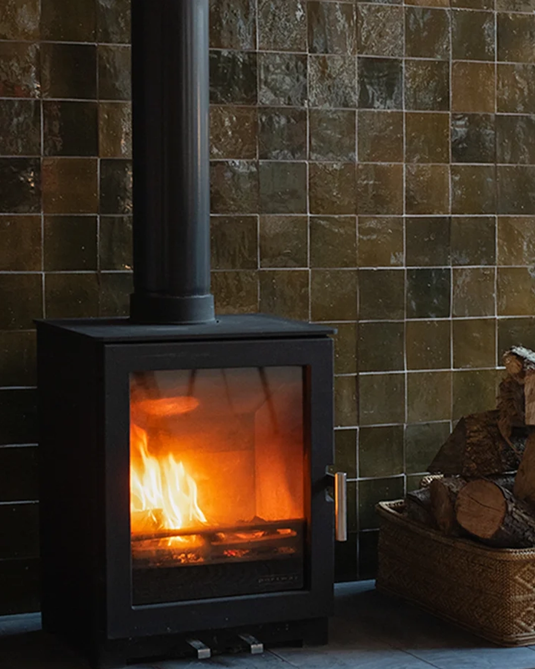 Tiled fireplace with dark zellige tiles